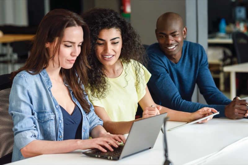 Multi-ethnic group studying with laptop